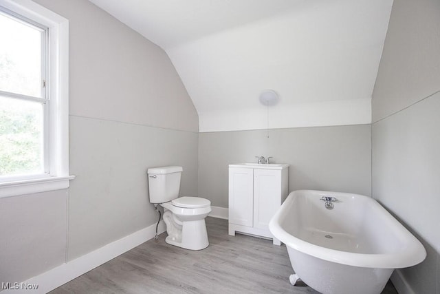 15517 Kipling Ave, Cleveland, OH 44110 - bathroom featuring vaulted ceiling, a freestanding bath, and wood finished floors