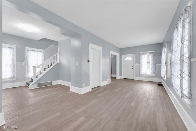 3009 Delmar Ave, Cleveland, OH 44109 - unfurnished living room with wood finished floors and stairway