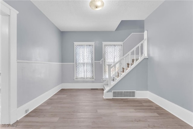 3009 Delmar Ave, Cleveland, OH 44109 - entrance foyer with stairway, wood finished floors, and a textured ceiling