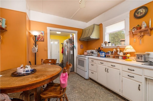 517 3rd St NW, New Philadelphia, OH 44663 - kitchen with electric range, wall chimney range hood, freestanding refrigerator, light countertops, and white cabinetry