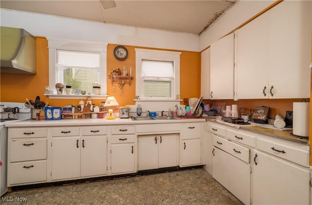 517 3rd St NW, New Philadelphia, OH 44663 - kitchen with wall chimney exhaust hood, light countertops, healthy amount of natural light, and white cabinetry