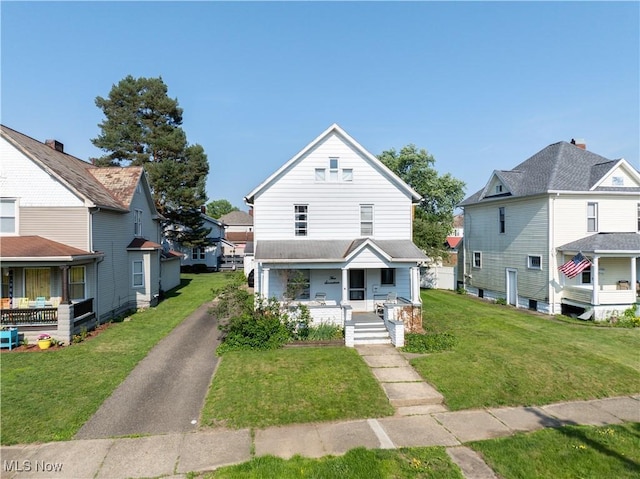 517 3rd St NW, New Philadelphia, OH 44663 - american foursquare style home with covered porch, a front lawn, and a residential view