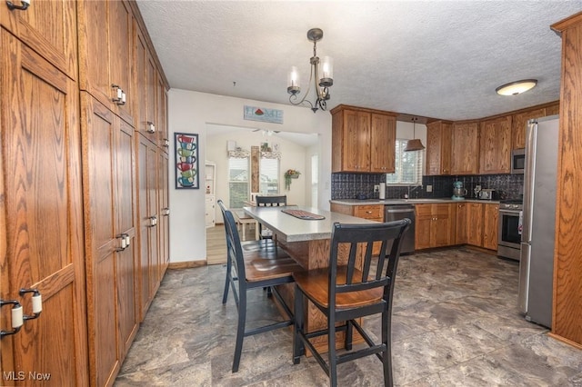 1902 26th Ave, Parkersburg, WV 26101 - kitchen featuring appliances with stainless steel finishes, brown cabinets, a textured ceiling, tasteful backsplash, and light countertops