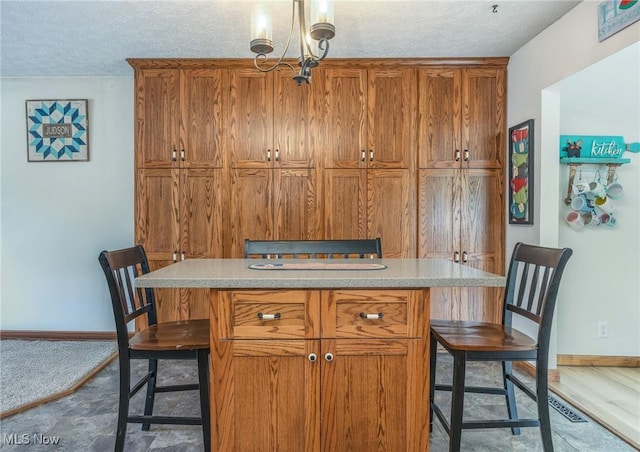 1902 26th Ave, Parkersburg, WV 26101 - kitchen featuring a breakfast bar area, brown cabinets, a textured ceiling, and light countertops