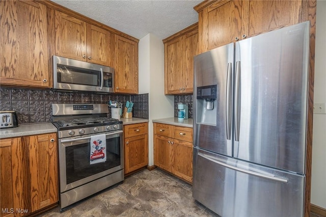 1902 26th Ave, Parkersburg, WV 26101 - kitchen with appliances with stainless steel finishes, brown cabinets, decorative backsplash, a textured ceiling, and light countertops