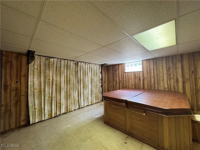 1281 Township Road 129, Adena, OH 43901 - below grade area featuring a drop ceiling, wooden walls, and light floors