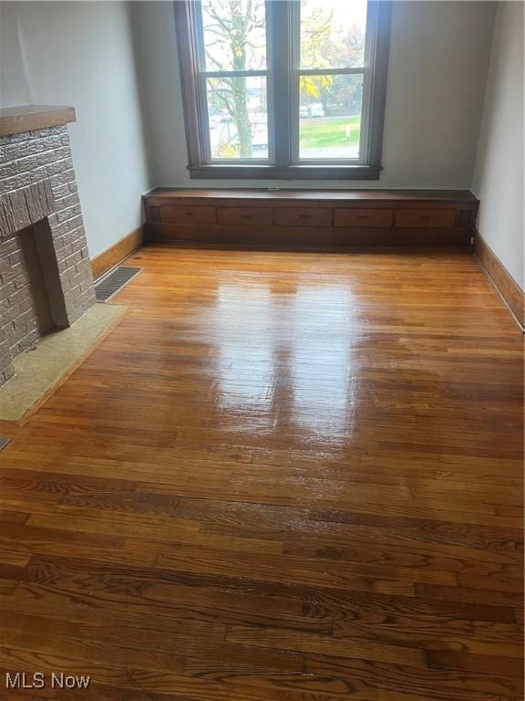 212 S 11th St, Cambridge, OH 43725 - unfurnished living room with light wood finished floors and a brick fireplace