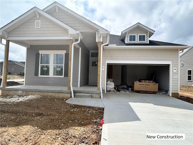 8928 Camden Rd NW, Massillon, OH 44646 - view of front facade featuring driveway, an attached garage, a porch, and a shingled roof