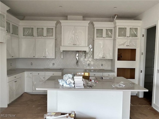 8928 Camden Rd NW, Massillon, OH 44646 - kitchen featuring a center island, decorative backsplash, glass insert cabinets, and white cabinetry