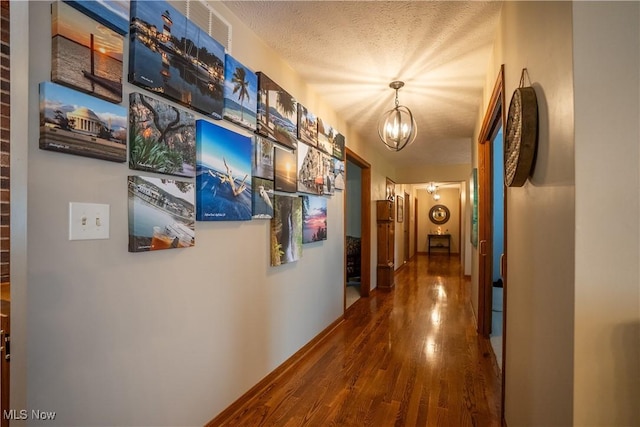5507 13th Ave, Vienna, WV 26105 - corridor featuring wood finished floors, a chandelier, and a textured ceiling