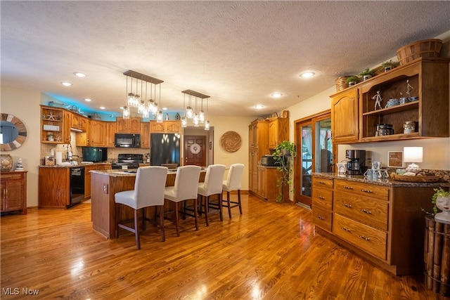 5507 13th Ave, Vienna, WV 26105 - kitchen with open shelves, black appliances, wood finished floors, brown cabinetry, and recessed lighting