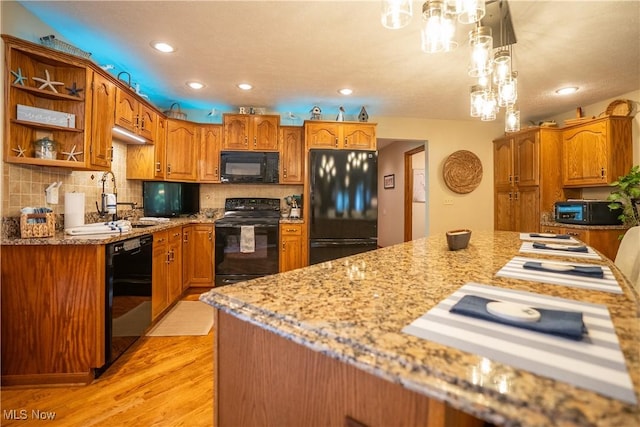 5507 13th Ave, Vienna, WV 26105 - kitchen with black appliances, light wood-style flooring, recessed lighting, light stone counters, and brown cabinets
