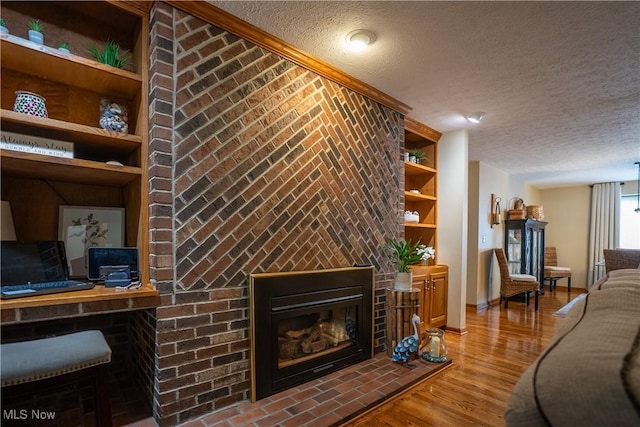 5507 13th Ave, Vienna, WV 26105 - living area featuring a textured ceiling, a fireplace, and wood finished floors