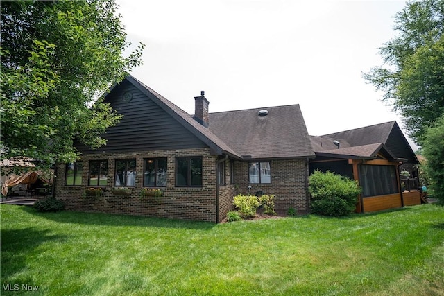 5507 13th Ave, Vienna, WV 26105 - back of house featuring a chimney, brick siding, a yard, and a sunroom