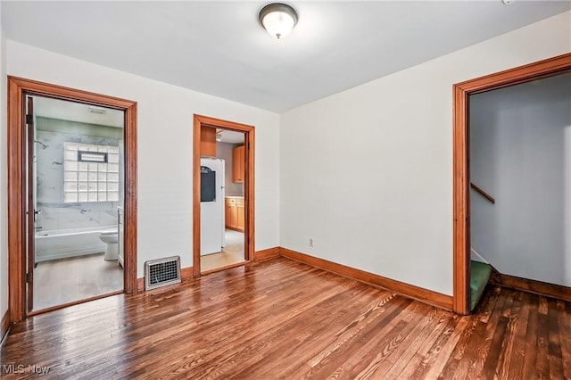 341 Kenmore Ave NE, Warren, OH 44483 - unfurnished bedroom with freestanding refrigerator, wood finished floors, and connected bathroom
