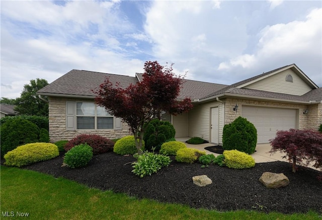 1011 Sequoia Dr NW, Strasburg, OH 44680 - view of front of property featuring stone siding, a garage, roof with shingles, and concrete driveway