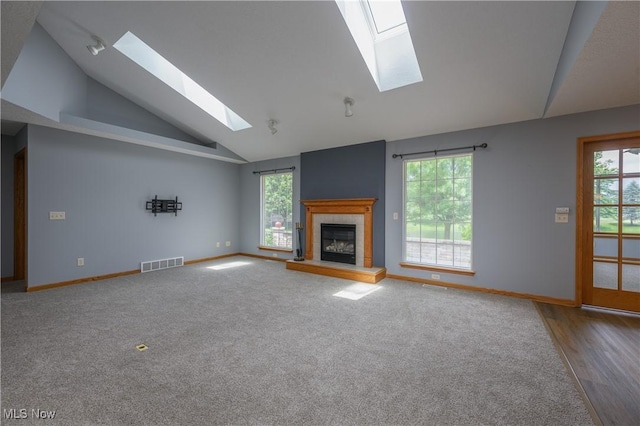 1011 Sequoia Dr NW, Strasburg, OH 44680 - unfurnished living room with a skylight, lofted ceiling, healthy amount of natural light, a tiled fireplace, and carpet