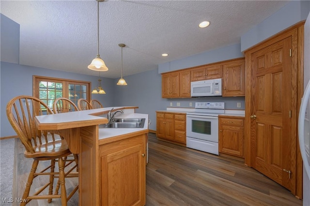 1011 Sequoia Dr NW, Strasburg, OH 44680 - kitchen featuring white appliances, a textured ceiling, a kitchen breakfast bar, light countertops, and a kitchen island with sink