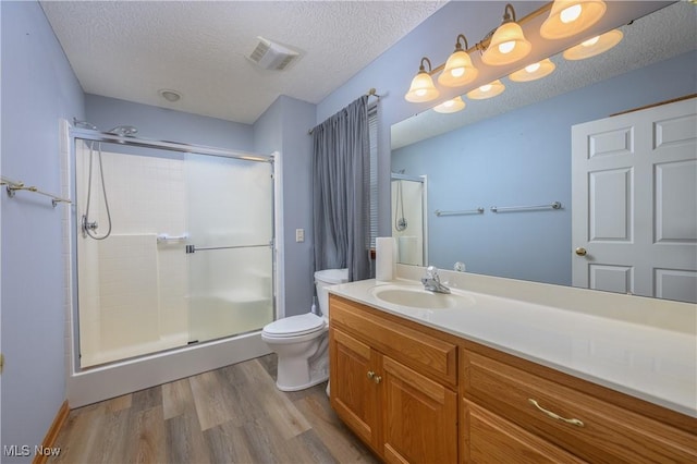 1011 Sequoia Dr NW, Strasburg, OH 44680 - full bath with wood finished floors, a stall shower, vanity, and a textured ceiling