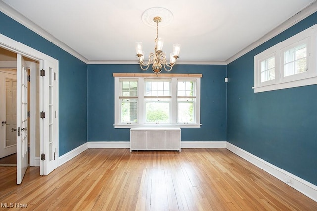 2611 Exeter Rd, Cleveland Heights, OH 44118 - unfurnished room featuring radiator, a chandelier, light wood finished floors, and crown molding