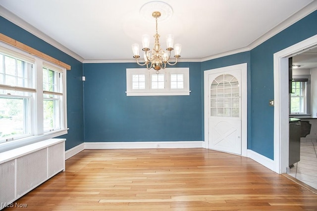 2611 Exeter Rd, Cleveland Heights, OH 44118 - unfurnished dining area featuring radiator heating unit, a chandelier, light wood-type flooring, healthy amount of natural light, and crown molding