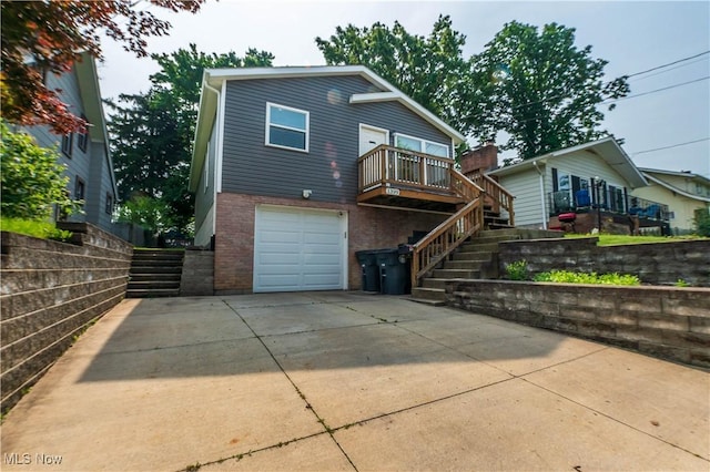 1399 Neptune Ave, Akron, OH 44301 - view of front of property with stairs, brick siding, an attached garage, concrete driveway, and a wooden deck