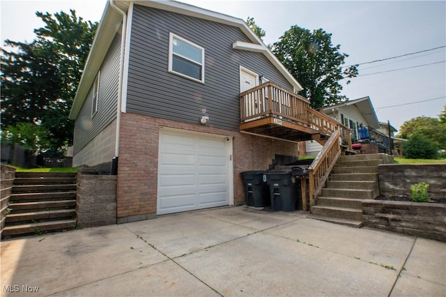 1399 Neptune Ave, Akron, OH 44301 - rear view of property featuring an attached garage, stairs, driveway, and a wooden deck