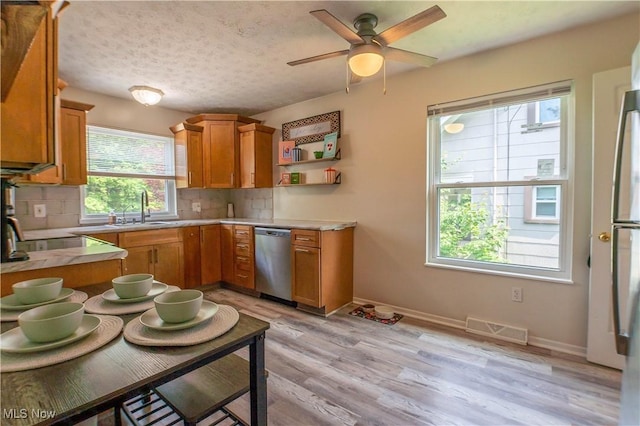 1399 Neptune Ave, Akron, OH 44301 - kitchen featuring dishwasher, light countertops, decorative backsplash, a ceiling fan, and light wood-style flooring
