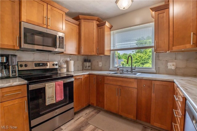 1399 Neptune Ave, Akron, OH 44301 - kitchen featuring stainless steel appliances, light countertops, light wood-style floors, and backsplash