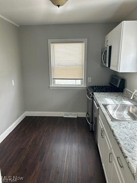1975 9th St SW, Akron, OH 44314 - laundry room with dark wood finished floors and baseboards