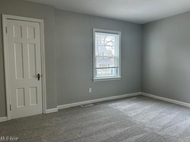 1975 9th St SW, Akron, OH 44314 - carpeted spare room featuring baseboards