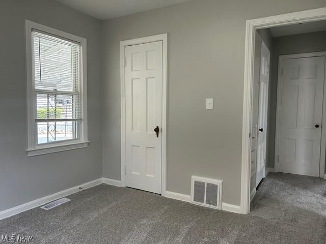 1975 9th St SW, Akron, OH 44314 - unfurnished bedroom featuring dark colored carpet