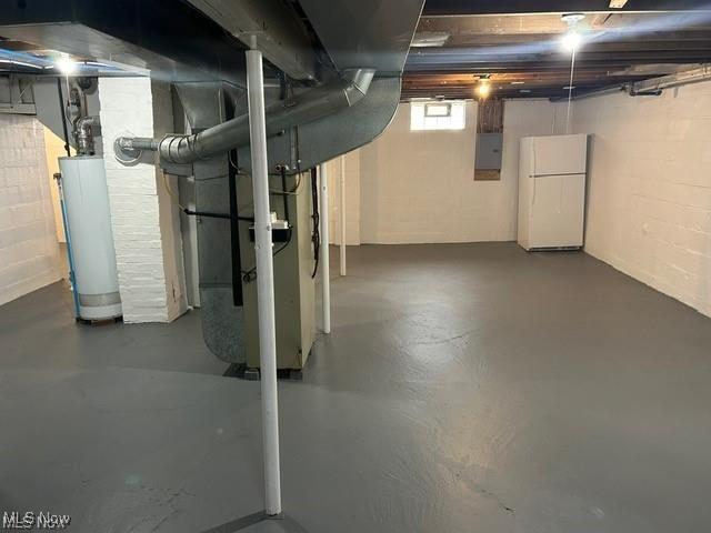 1975 9th St SW, Akron, OH 44314 - below grade area with gas water heater, freestanding refrigerator, electric panel, and concrete block wall