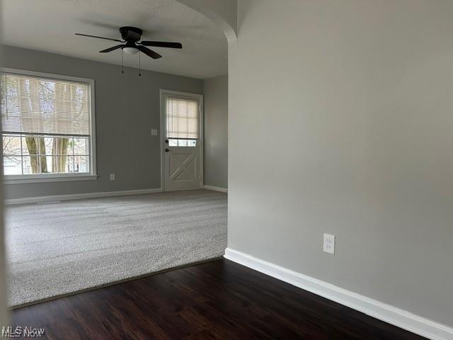 1975 9th St SW, Akron, OH 44314 - spare room featuring ceiling fan, arched walkways, and dark wood finished floors