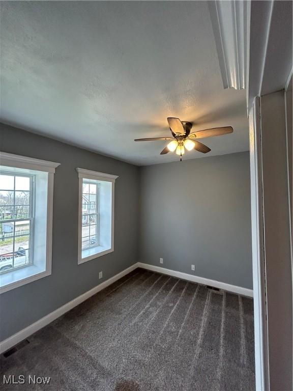 10545 Main St, Norwich, OH 43767 - spare room with ceiling fan and dark colored carpet