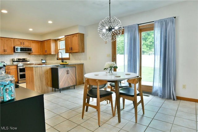 2304 Bianca Ln, Cortland, OH 44410 - kitchen featuring appliances with stainless steel finishes, backsplash, light countertops, a chandelier, and light tile patterned floors