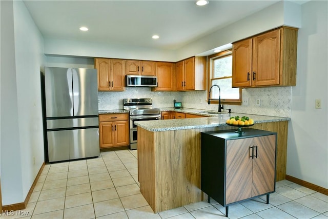 2304 Bianca Ln, Cortland, OH 44410 - kitchen featuring stainless steel appliances, brown cabinets, a peninsula, and recessed lighting