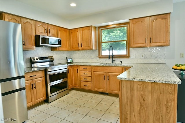 2304 Bianca Ln, Cortland, OH 44410 - kitchen featuring stainless steel appliances, a peninsula, light stone countertops, backsplash, and recessed lighting