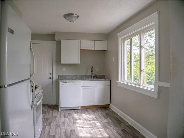 3814 Russell Ave, Parma, OH 44134 - kitchen featuring white appliances, white cabinetry, light stone countertops, and light wood finished floors