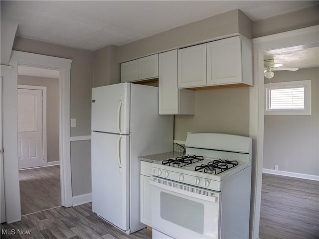 3814 Russell Ave, Parma, OH 44134 - kitchen with white appliances, a ceiling fan, light wood-style flooring, white cabinetry, and light stone countertops
