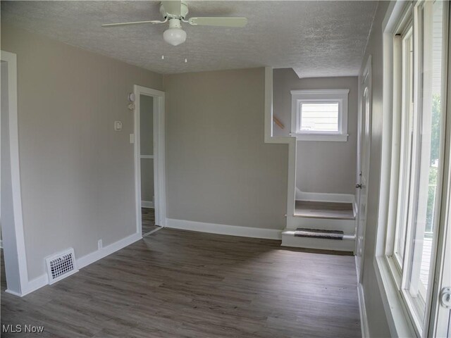 3814 Russell Ave, Parma, OH 44134 - empty room featuring stairs, wood finished floors, a textured ceiling, and a ceiling fan