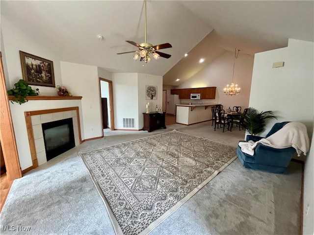 9264 Sharrott Rd Unit 104, Youngstown, OH 44514 - living room featuring light colored carpet, vaulted ceiling, ceiling fan, a tile fireplace, and a chandelier