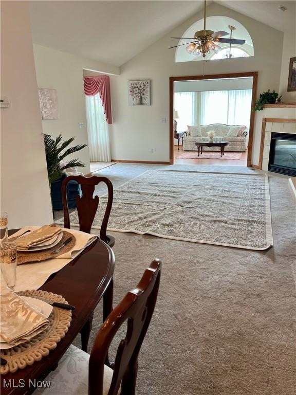 9264 Sharrott Rd Unit 104, Youngstown, OH 44514 - dining space with ceiling fan, vaulted ceiling, carpet, and a tiled fireplace