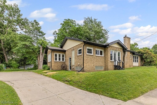 3549 Kent Rd, Stow, OH 44224 - view of property exterior featuring entry steps, a chimney, brick siding, and a lawn