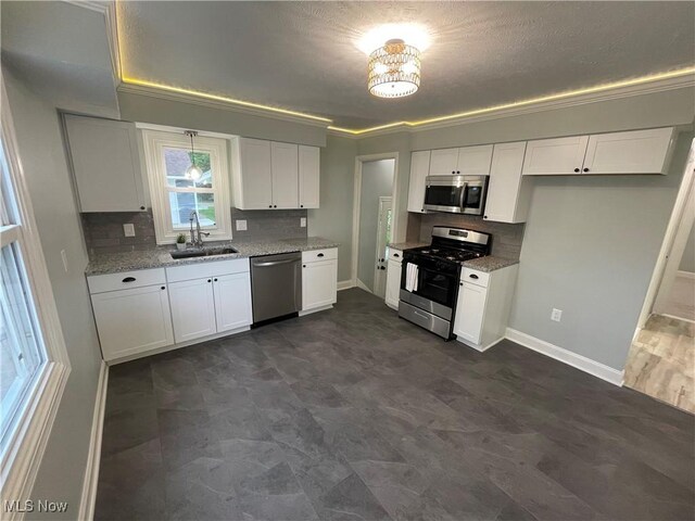 16005 Walvern Blvd, Maple Heights, OH 44137 - kitchen featuring appliances with stainless steel finishes, backsplash, white cabinetry, light stone counters, and ornamental molding