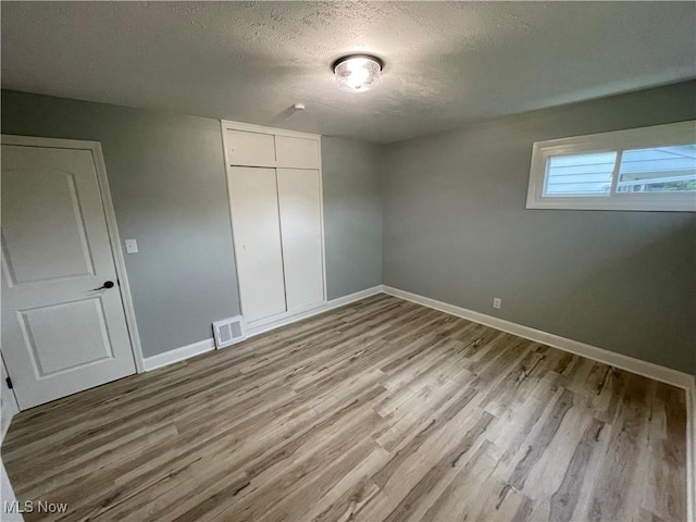 16005 Walvern Blvd, Maple Heights, OH 44137 - unfurnished bedroom with wood finished floors, a textured ceiling, and a closet