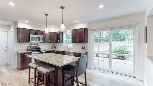 4314 Cheval Cir, Stow, OH 44224 - kitchen with stainless steel appliances, light wood-style flooring, dark brown cabinets, decorative backsplash, and recessed lighting