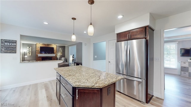 4314 Cheval Cir, Stow, OH 44224 - kitchen with freestanding refrigerator, light wood-style floors, dark brown cabinets, a kitchen island, and open floor plan
