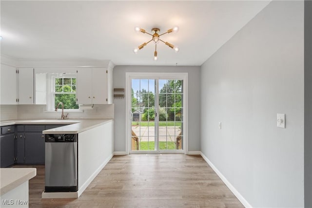 541 Broad St, Wadsworth, OH 44281 - kitchen with stainless steel dishwasher, light countertops, light wood-style floors, decorative backsplash, and white cabinetry