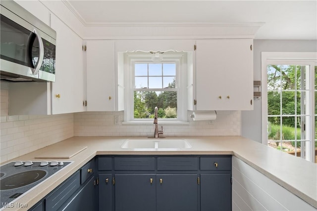 541 Broad St, Wadsworth, OH 44281 - kitchen featuring stainless steel microwave, electric cooktop, light countertops, plenty of natural light, and crown molding